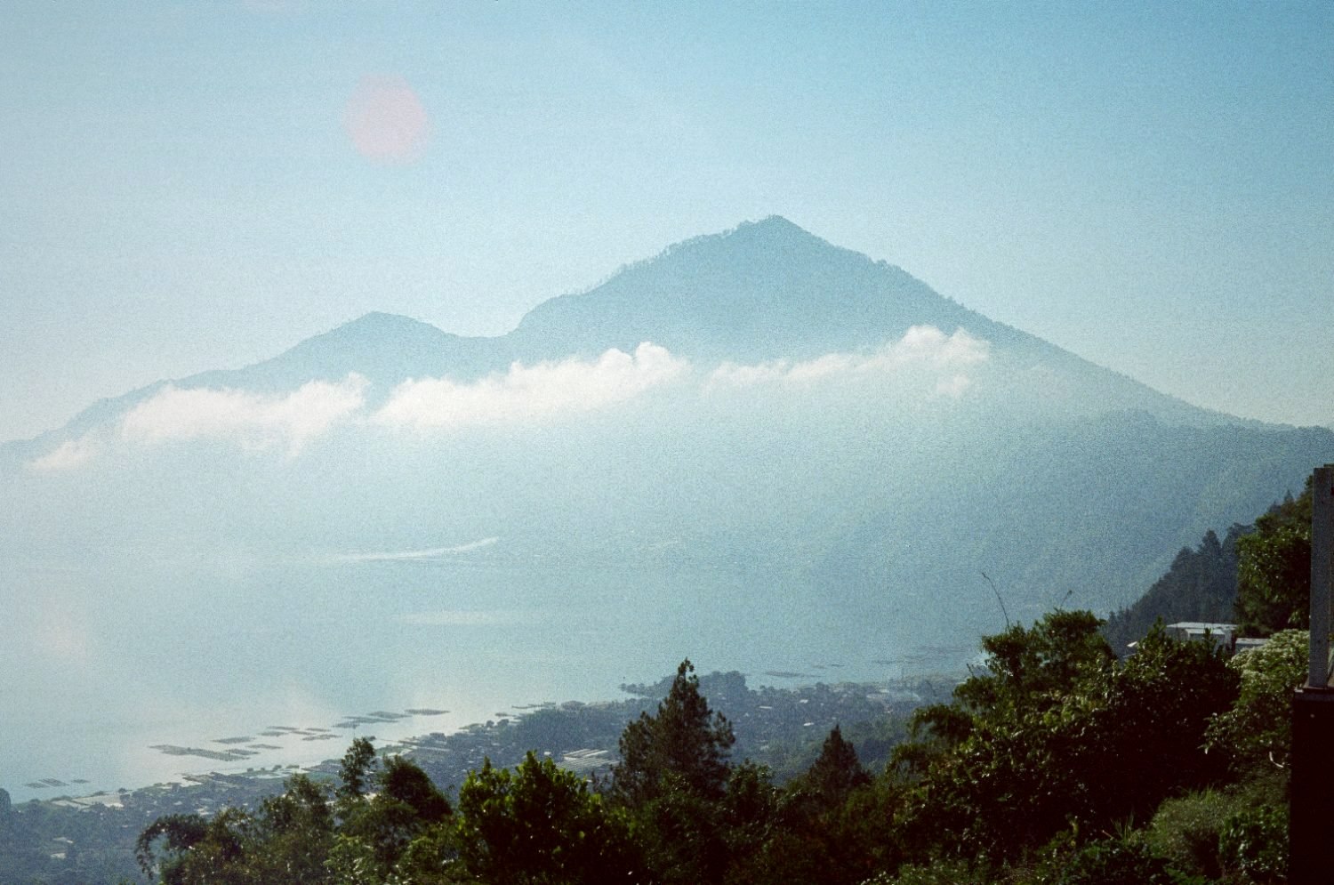 Mount Batur volcano above the lake in morning haze