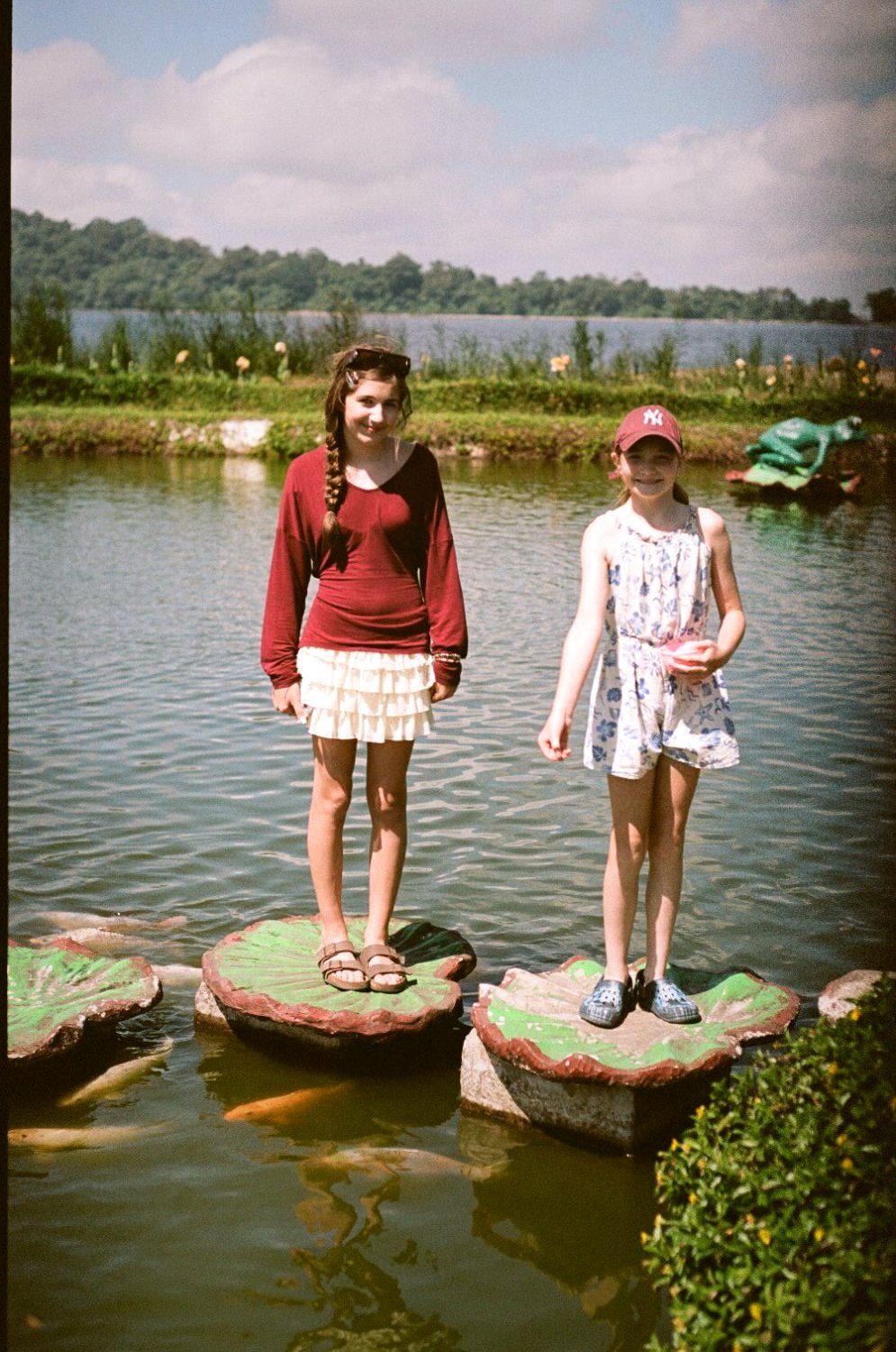 Two girls standing on stepping stones in a lake